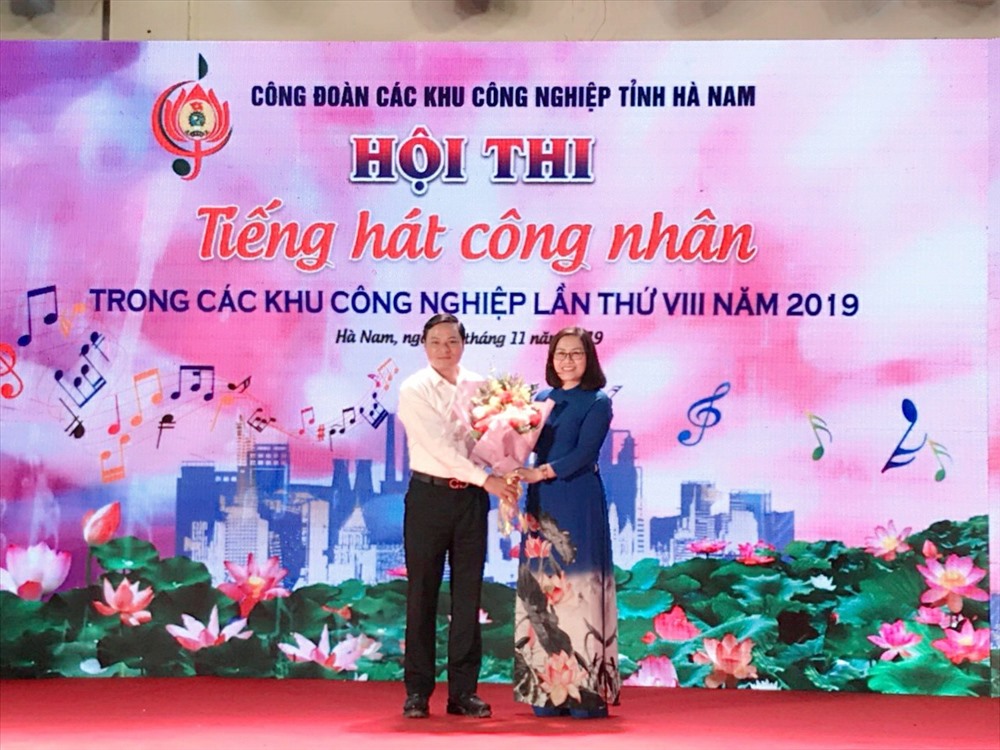 Đồng chí Vũ Thị Minh Phượng – Ủy viên Ban Chấp hành Tổng Liên đoàn lao động Việt Nam, Chủ tịch Công đoàn các Khu công nghiệp tỉnh - thay mặt Ban Tổ chức nhận hoa chúc mừng từ đồng chí Trần Văn Kiên – Trưởng Ban Quản lý các Khu công nghiệp tỉnh Công đoàn các Khu công nghiệp tỉnh.