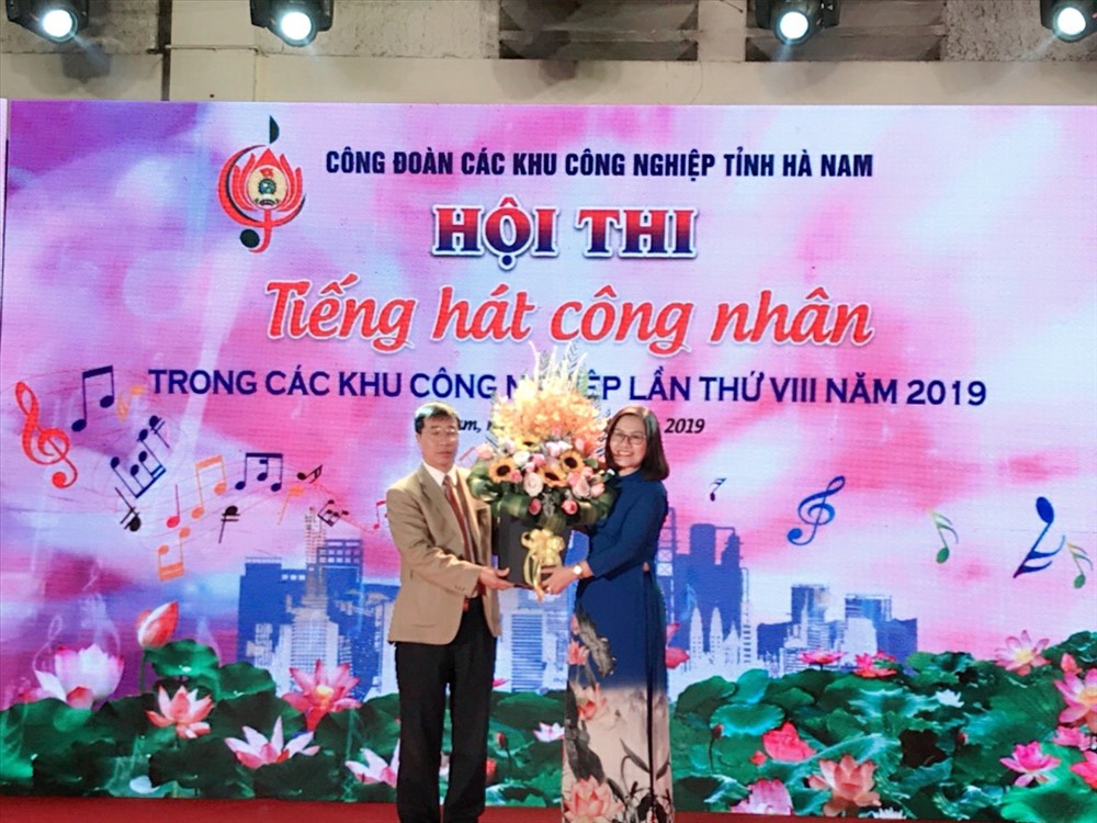 Đồng chí Vũ Thị Minh Phượng – Ủy viên Ban Chấp hành Tổng Liên đoàn lao động Việt Nam, Chủ tịch Công đoàn các Khu công nghiệp thay mặt Ban Tổ chức nhận hoa chúc mừng từ đồng chí Trịnh Văn Bừng – Chủ tịch Liên đoàn Lao động tỉnh Hà Nam.