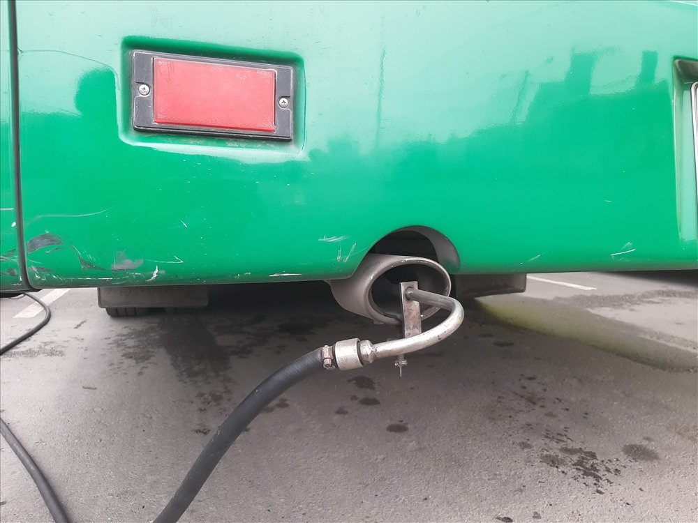 Gắn thiết bị đo khí thải vào ống xả của một xe buýt tại TP.Hồ Chí Minh. Ảnh: M.Q