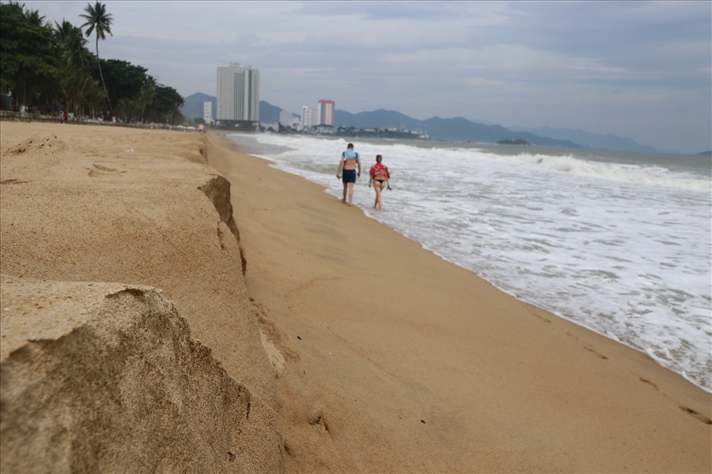 Khi xuống biển nhiều người dân và du khách bất ngờ khi cát bị sóng đánh lên cao tạo thành bờ tường cao hơn nửa m. Ảnh: Phương Linh