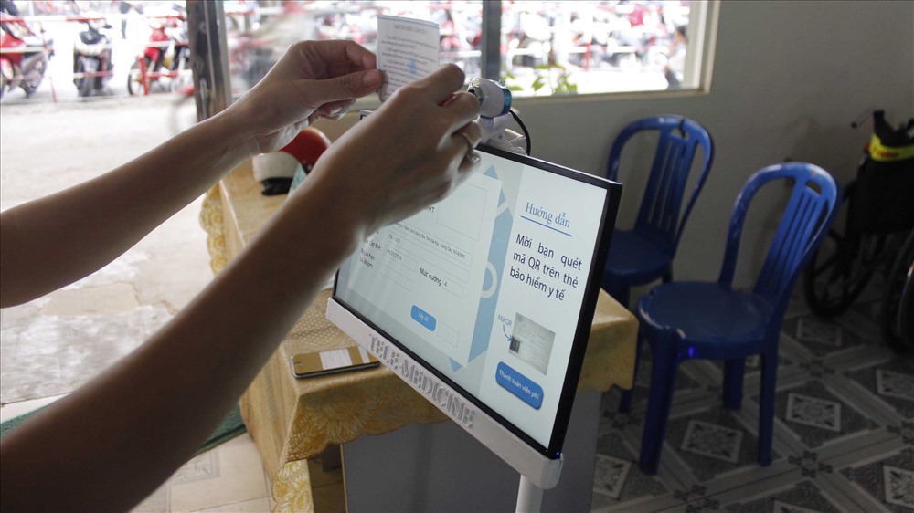Robot nhận dạng mã QR trên thẻ bảo hiểm để lưu thông tin của bệnh nhân vào hồ sơ. Ảnh: QUỲNH NHƯ