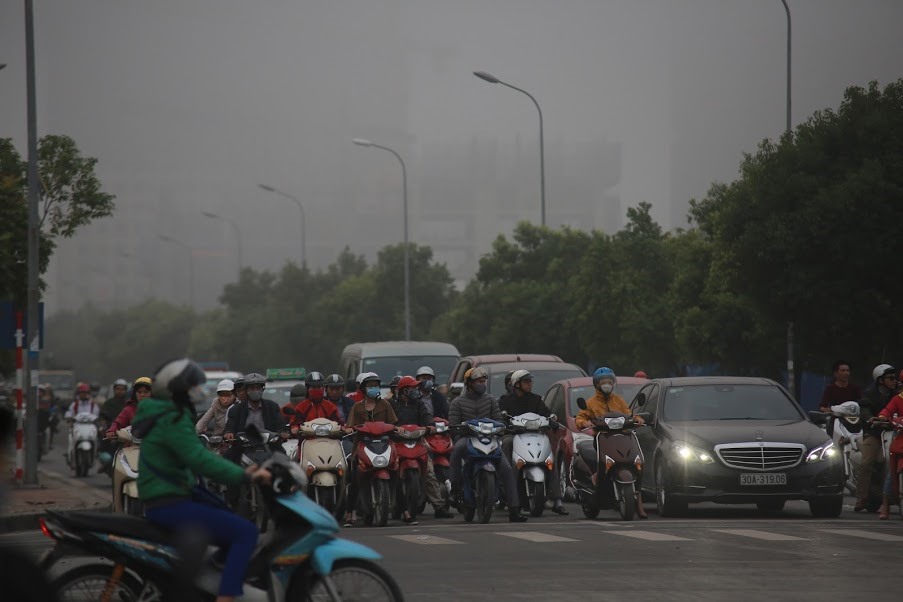 Giữa trưa, người tham gia giao thông phải bật đèn xe để di chuyển.