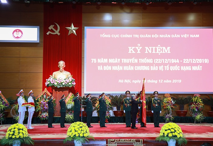 Đồng chí Trần Quốc Vượng gắn Huân chương Bảo vệ Tổ quốc hạng Nhất lên Quân kỳ Quyết thắng của Tổng cục Chính trị. Ảnh BQP