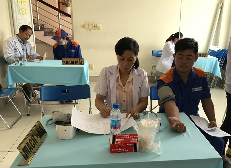 Bà Ngân đo mạch huyết áp cho công nhân. Ảnh: AX