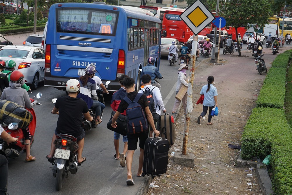 Dịp Tết các năm trước, nhiều hành khách phải xuống taxi xách vali chạy bộ vào bến xe Miền Đông do kẹt xe. Ảnh: M.Q