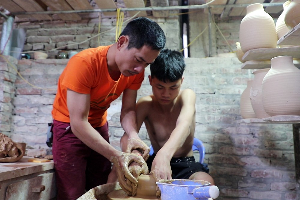 Giờ đây ngồi cạnh bố bên chiếc bàn xoay, cậu con trai Phạm Duy Anh 17 tuổi cũng đã tập tành nghề gốm như ngày xưa anh Đạo học nghề của bố. “Nó học được nghề gốm của cha ông cũng tốt thôi, nhưng vất vả và nghèo lắm“, anh nói.