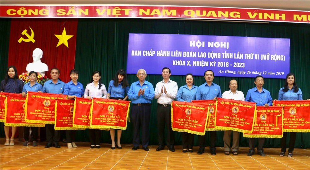 Chủ tịch LĐLĐ An Giang Nguyễn Thiện Phú trao cờ cho các đơn vị đạt thành tích xuất sắc năm 2019. Ảnh: LT