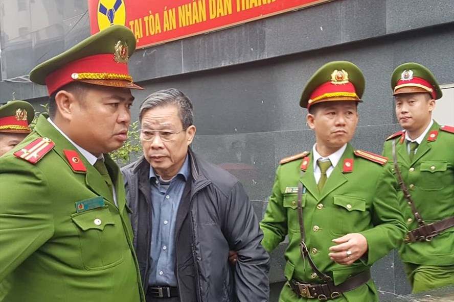 Cựu Bộ trưởng Nguyễn Bắc Son (áo đen) bị dẫn giải về trại tạm giam sau phiên tòa ngày 24.12.