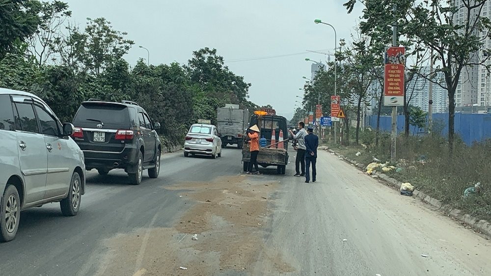 Xe container rơi vãi dầu thải trên Đại lộ Thăng Long.