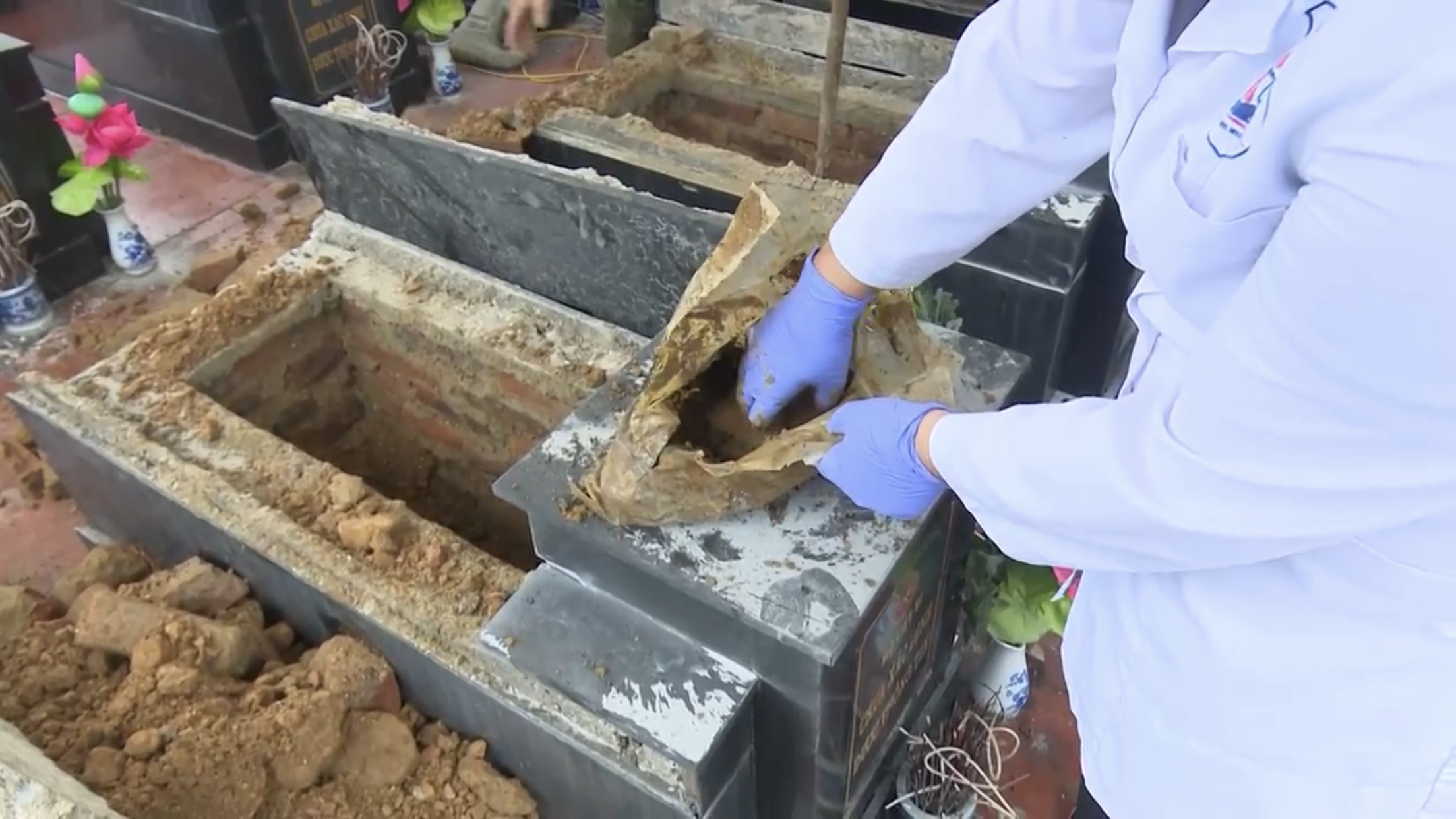 Cơ quan chức năng phát hiện đất đá trong mộ liệt sĩ. Ảnh: Tâm Am