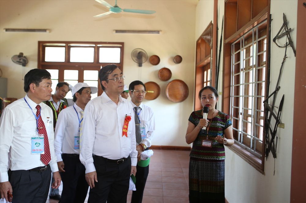 Ông Nguyễn Đức Chính (hàng trên, thứ 2 từ trái sang) - Chủ tịch UBND tỉnh Quảng Trị cùng lãnh đạo địa phương nghe giới thiệu về những vật dụng dùng trong sinh hoạt của đồng bào Vân Kiều, Pa Cô. Ảnh: Hưng Thơ.