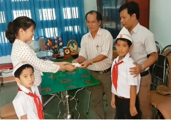 Nhặt được túi vải màu đỏ, hai em em Nguyên và Hưng đã giao nộp cho hiệu trưởng.Ảnh: X.V