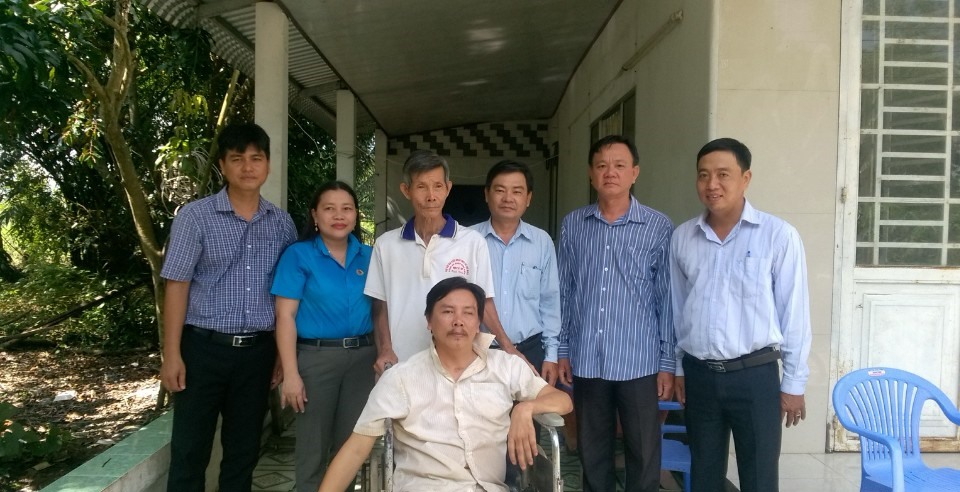 Đoàn công tác chụp ảnh cùng với gia đình công nhân bị tai nạn lao động. ảnh: Thành Nhân