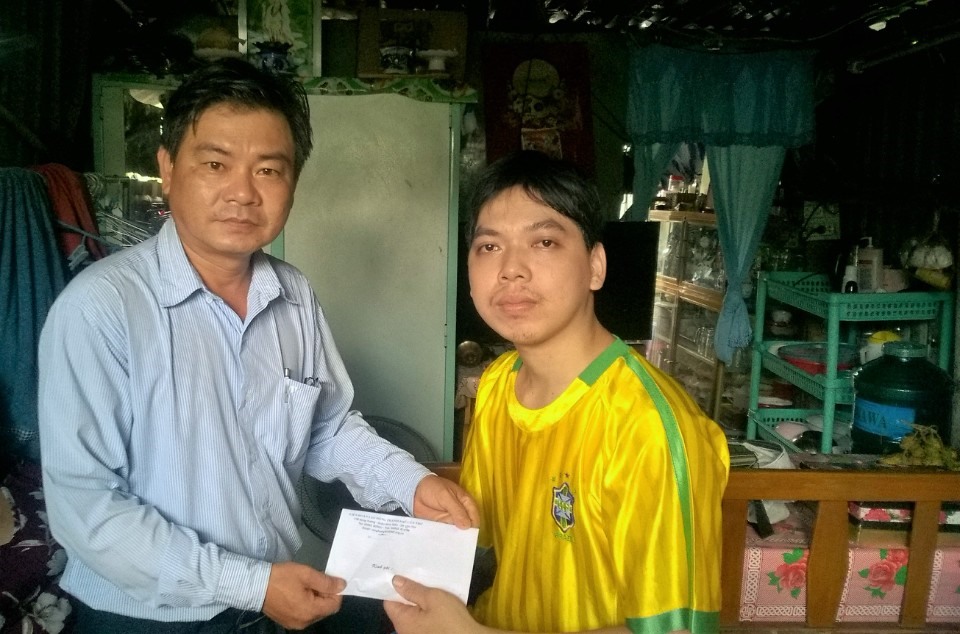 Ông Đoàn Văn Dũng - phó Chủ tịch LĐLĐ TP Cần Thơ trao hỗ trợ 1 triệu đồng cho anh Tuấn công nhân bị tại nạn lao động. ảnh: Thành Nhân