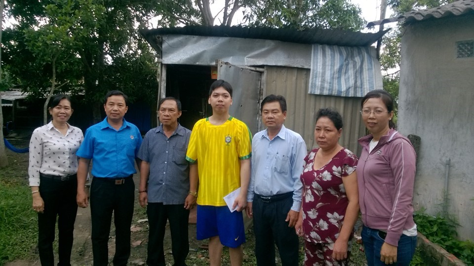 Đoàn công tác chụp hình cùng công nhân bị tai nạn lao động tại Quận Bình Thủy. ảnh: Thành Nhân