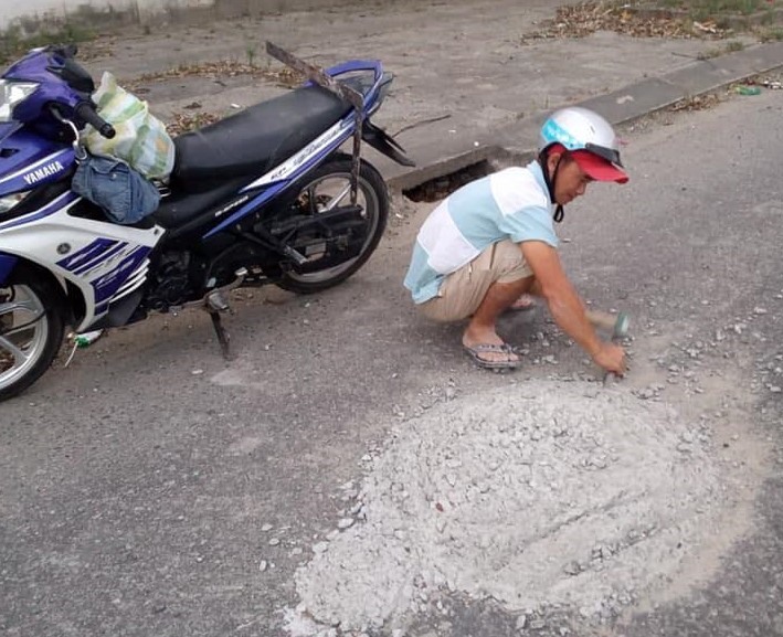 Anh Hùng đục mảng bên tông rơi vãi và bám trên mặt đường. ảnh: MXH
