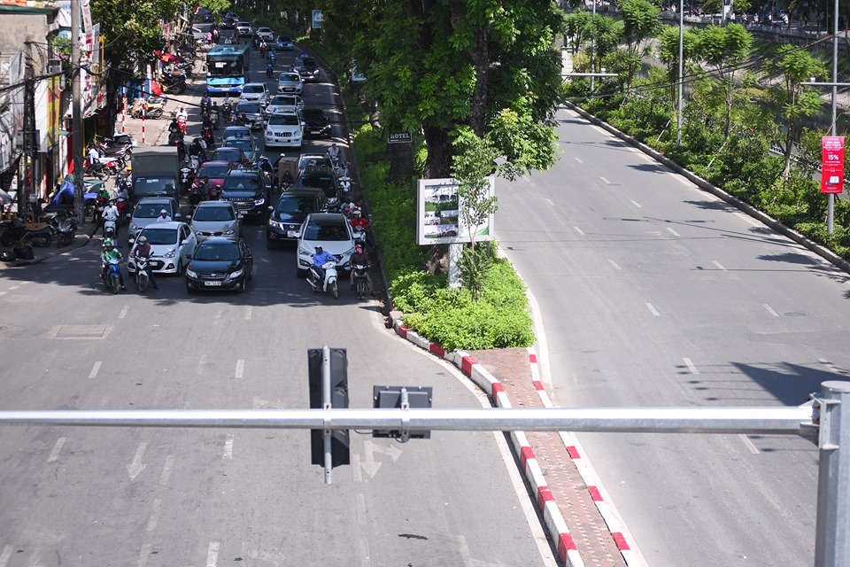 Những người đi đường cố gắng tìm những bóng râm khi chờ đèn đỏ.