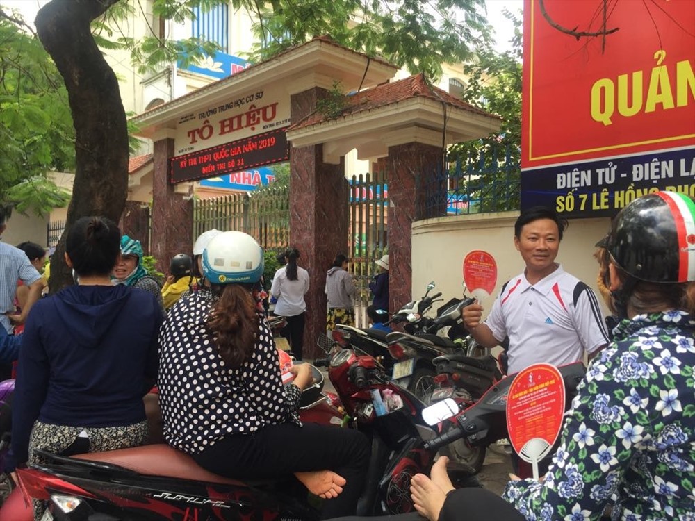 Các phụ huynh đợi con thi được các tình nguyện viên tặng quạt chống nóng - ảnh HH