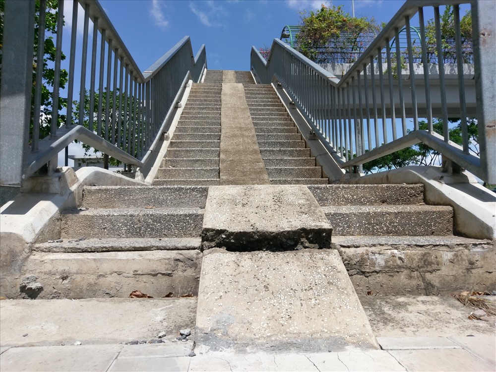 Vị trí bậc thang lên cầu vượt phần vỉa hè bị “rớt” xuống khoảng 10 cm so với chân cầu. Ảnh: M.Q
