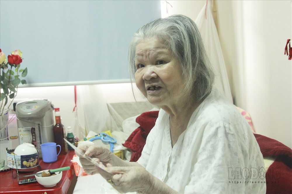 Bà Hoàng Thị Cẩm kể lại câu chuyện với người chồng của mình. Ảnh Vương Đông