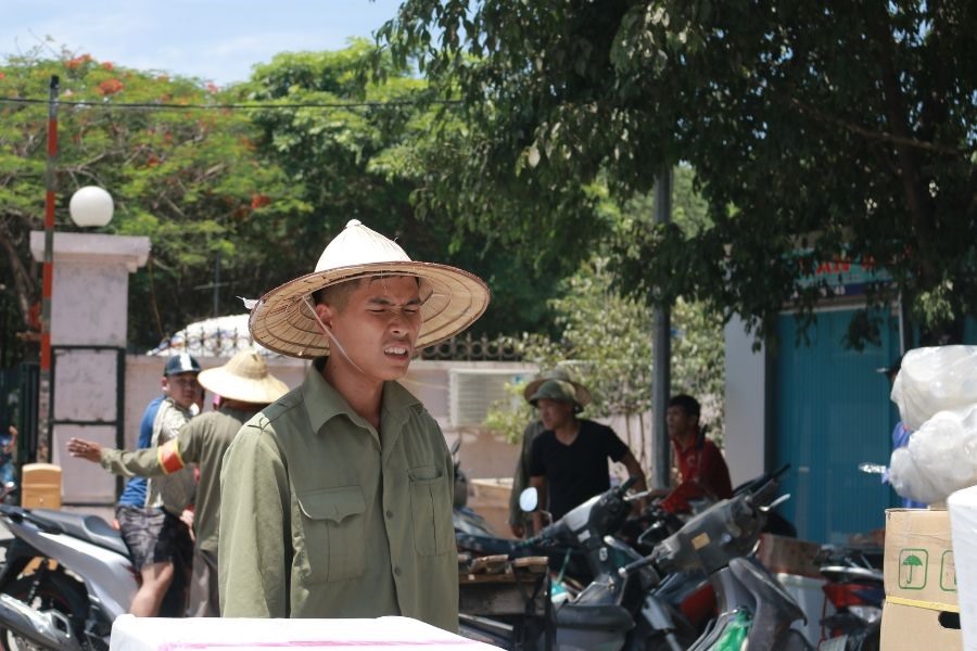 Không khí tất bật của khu xếp hàng phía sau Bến xe khách Mỹ Đình (phường Mỹ Đình, Nam Từ Liêm) dường như không làm cho những người cửu vạn mệt mỏi bằng cái nắng nóng của thời tiết.