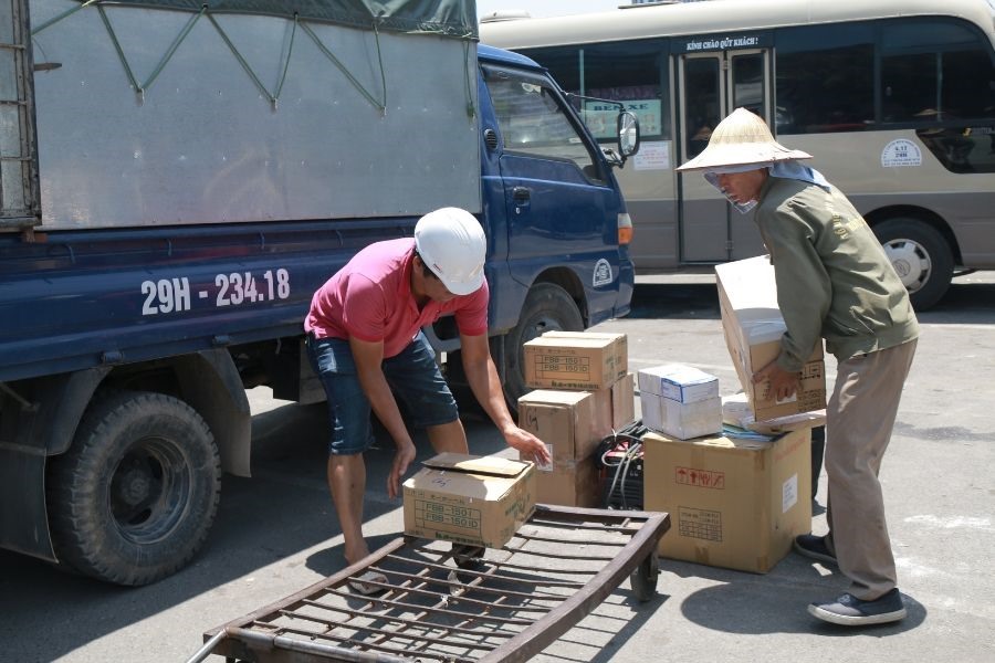 Những đôi bàn tay nhuần nhuyễn với dây thừng, thùng hàng miệt mài làm việc dưới nắng hè đổ lửa.