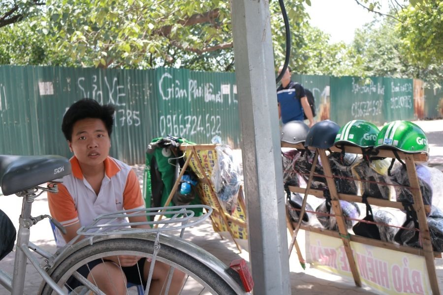 Để mẹ có thêm thời gian nghỉ ngơi, Nguyễn Văn Tú (Đình Thôn, phường Mỹ Đình, Nam Từ Liêm) ra trông hàng giúp mẹ ở mặt đường gần nhà. “Tối nào mẹ đi làm về cũng kêu nhức đầu vì ngồi ngoài trời nắng nhiều. Vì thế những lúc được nghỉ học, em ra đây ngồi trông hàng cho mẹ”, Tú tâm sự.