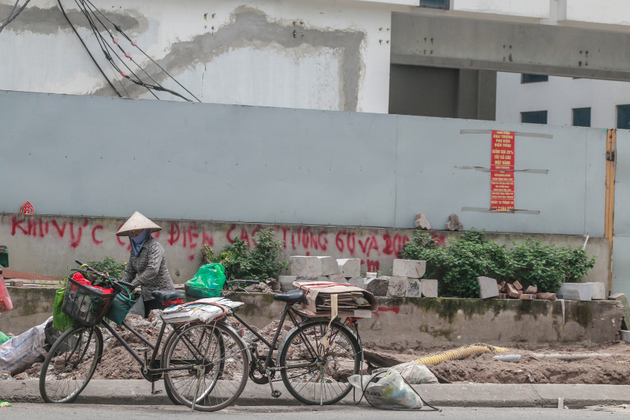 Gạch lát vỉa hè bị xới tung, được để bên cạnh vật liệu công trình và rác thải của người dân.