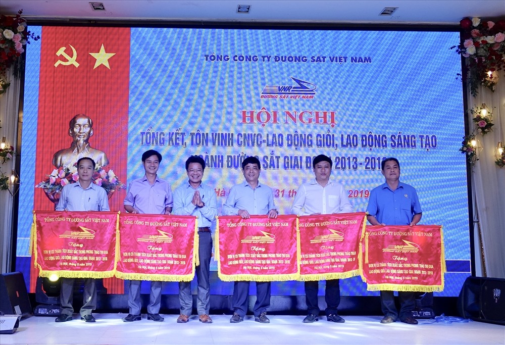 Phó Tổng Giám đốc phụ trách điều hành Tổng công ty ĐSVN Đặng Sỹ Mạnh (thứ ba từ trái qua) trao Cờ cho các đơn vị có thành tích xuất sắc