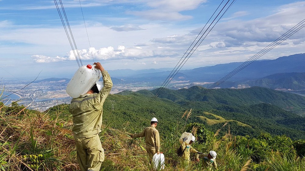 Công nhân ngành điện tải nước để dập lửa. Ảnh: N.T