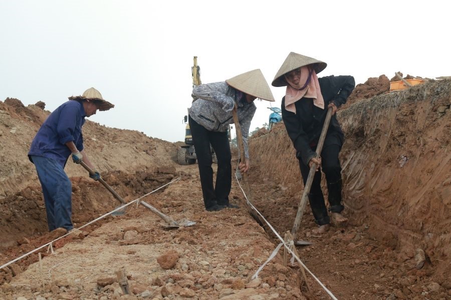 Mỗi ngày có hơn 20 công nhân “đội” nắng làm việc tại công trình. Các công nhân làm việc từ 6h30 khi trời còn mát và tranh thủ nghỉ trưa sớm lúc 10h30 khi mặt trời lên cao. Từ mặt đê, công nhân đào sâu xuống khoảng một mét để đổ cốt thép bê tông. Công trình được thiết kế theo kỹ thuật bê tông cốt thép dự ứng lực.