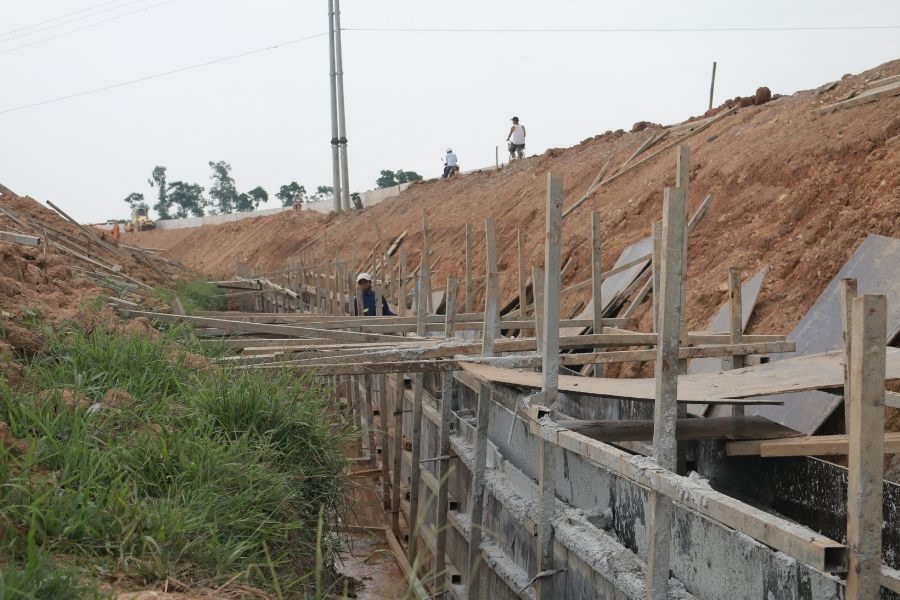 Bên trong đê, một đường mương thoát nước dài 300m và rộng 1m cũng đang được công nhân tích cực hoàn thiện trả lại cho dân.
