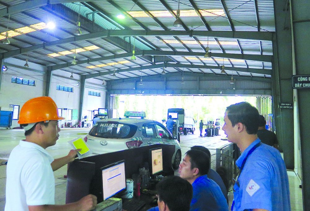 Một lái xe giải thích với đăng kiểm viên về việc đã nộp phạt nhưng vẫn bị chặn đăng kiểm