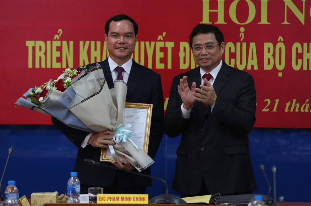 Đồng chí Phạm Minh Chính (bên trái) trao quyết định điều động, chỉ định, tặng hoa tới đồng chí Nguyễn Đình Khang. Ảnh: Sơn Tùng