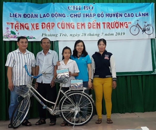Chủ tịch LĐLĐ huyện Cao Lãnh Phạm Thị Xuân Mai trao xe đạp và tập cho em Đặng Quyền Thanh Thảo. Ảnh:Hồng Lan