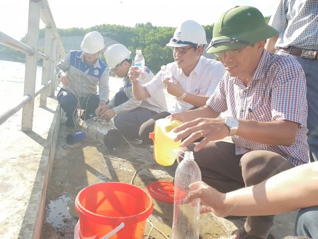 Đoàn lấy mẫu nước để phân tích tìm nguyên nhân. Ảnh: TN