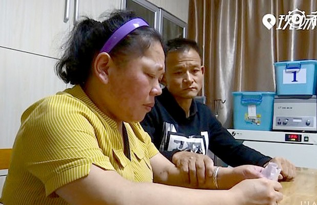 Anh Kha an ủi vợ sau khi vợ anh bốc được phiếu tiếp tục sống để chăm con. Ảnh: ncnews.