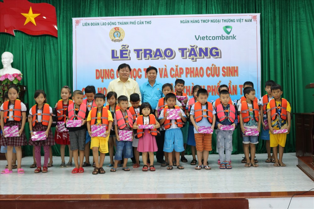 ông Bùi Văn Nhuận và ông Huỳnh Minh Truyền trao quà cho các em học sinh.
