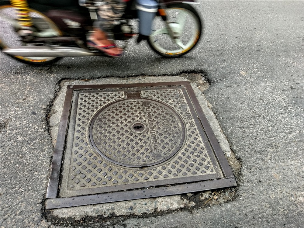 Nắp cống lồi lõm làm trên đường Trường Sa (Q.Phú Nhuận) làm người đi đường phải chạy nép sang một bên. Ảnh: M.Q