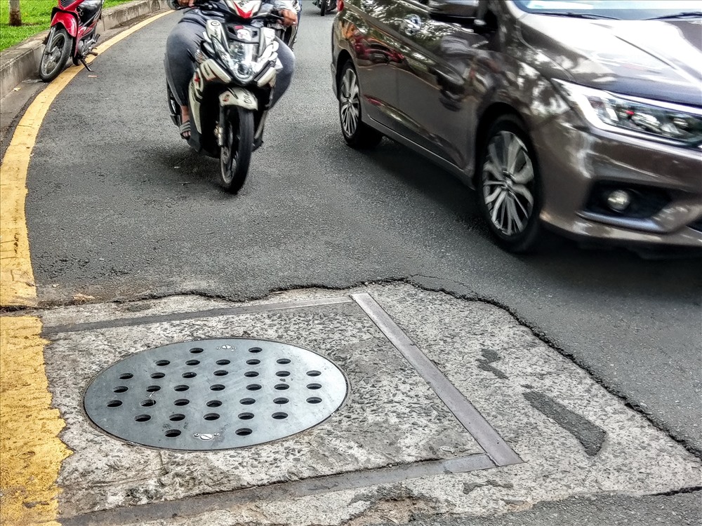 Người dân khi di chuyển qua nắp cống đều chạy nép sang một bên để né ổ gà, dễ xảy ra va quẹt khi người phía sau không kịp phản ứng. Ảnh: M.Q