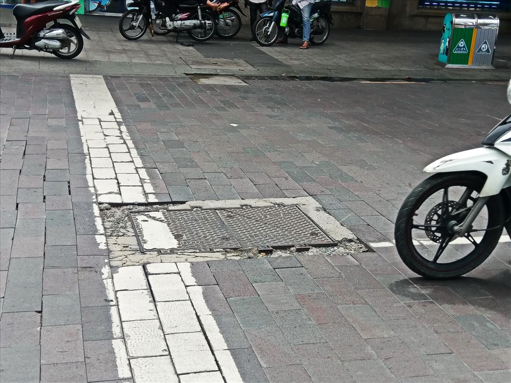 Khu vực nắp cống trên đường Nguyễn Huệ (Q.1) xuất hiện ổ gà “bẫy” người đi đường. Ảnh: M.Q