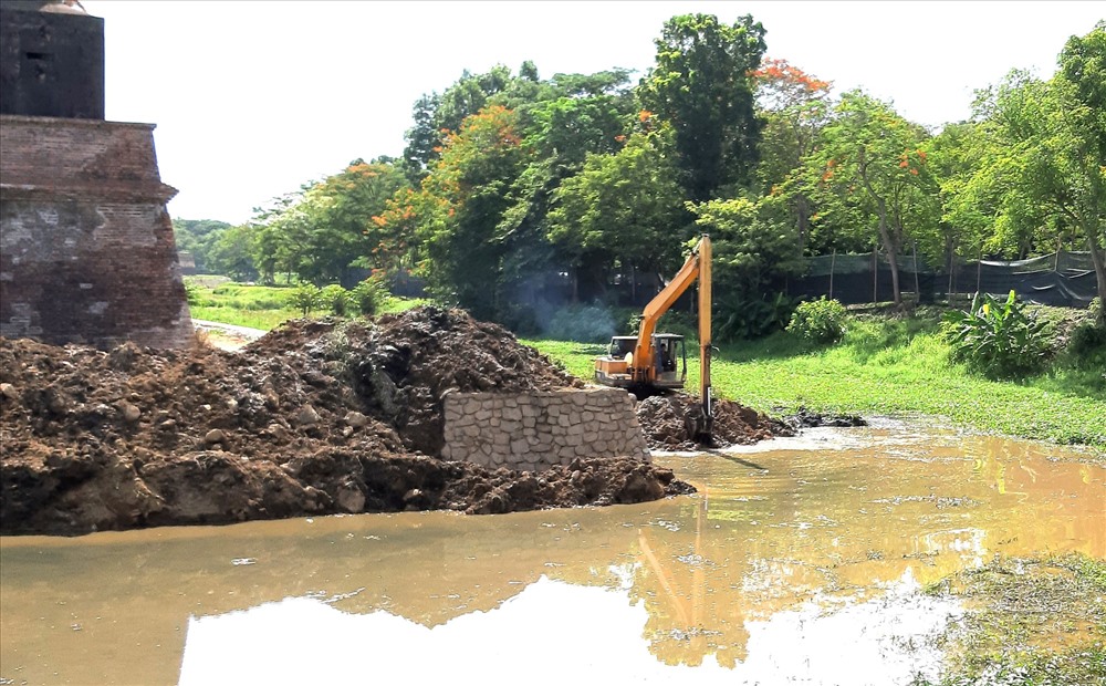Sau một thời gian tạm ngưng, đơn vị thi công đang nạo vét lòng hào để thu gom đá cũ, phục vụ việc khắc phục. Ảnh: PĐ.