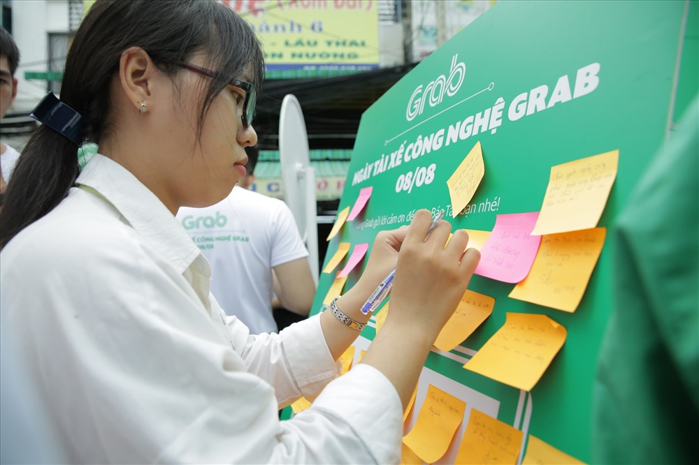Một bạn trẻ chăm chú viết lời cảm ơn gửi đến các tài xế công nghệ Grab