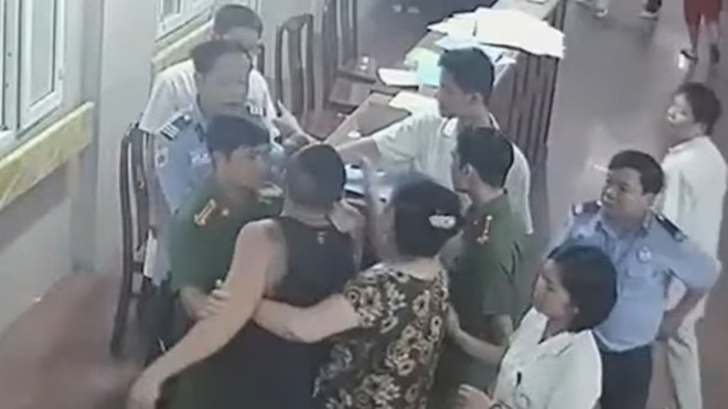 Dù được mọi người can ngăn nhưng đối tượng Bắc vẫn chửi bới và lao vào đánh nhân viên y tế. Ảnh: (Cắt từ clip)