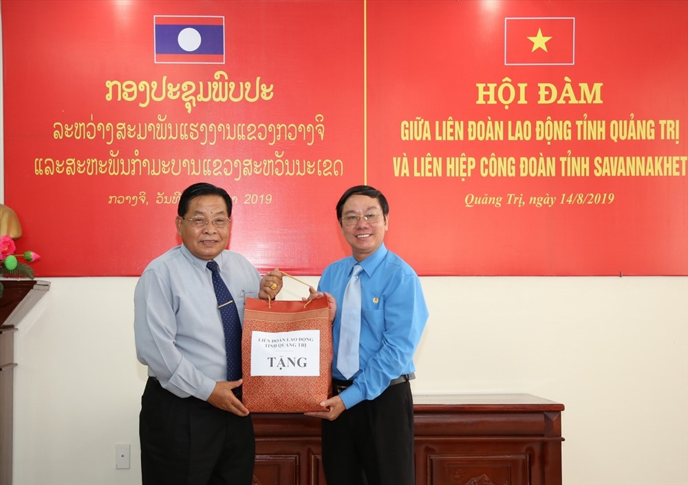 Ông Nguyễn Thế Lập - Tỉnh Ủy viên, Ủy viên BCH Tổng LĐLĐ Việt Nam, Chủ tịch LĐLĐ tỉnh Quảng Trị tặng quà cho ông Bun Liêng Chăn Văn Pheng - Chủ tịch LHCĐ tỉnh Savannakhet. Ảnh: Hưng Thơ.