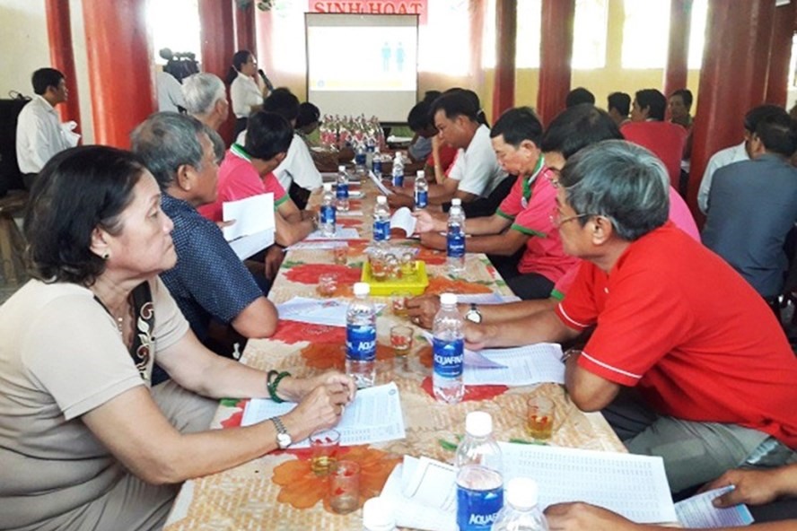 Cán bộ BHXH tuyên truyền về BHXH tự nguyện cho người dân tại Hội quán Mỹ Thanh, xã Bình Hàng Trung, huyện Cao Lãnh, tỉnh Đồng Tháp. Ảnh: Đ.T