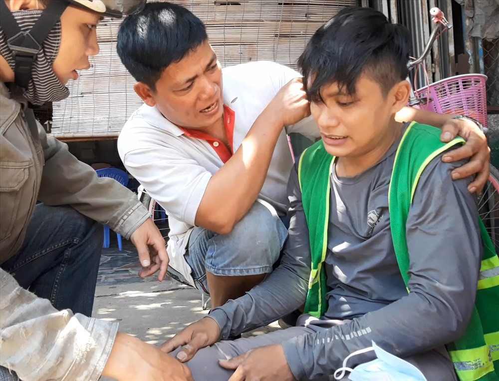 Anh Hựu (giữa) bế nam thanh niên bị tai nạn vào vỉa hè rồi nhanh chóng đưa nạn nhân đến bệnh viện cấp cứu.