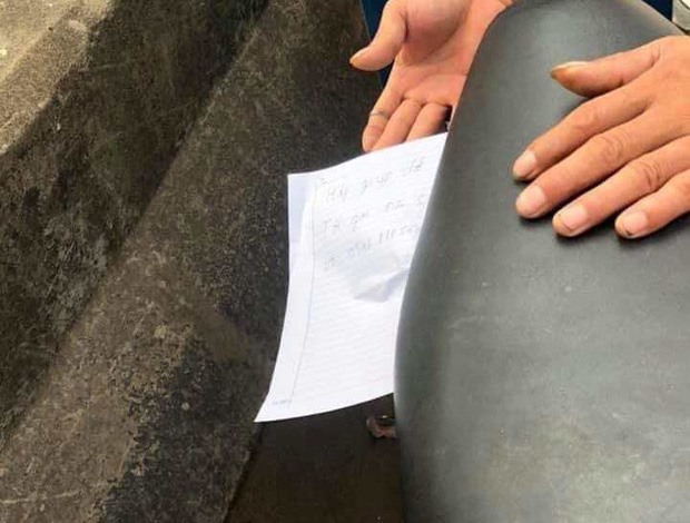 Tờ giấy ghi số điện thoại trong cốp xe người phụ nữ nhảy cầu tự tử. Ảnh: CAND