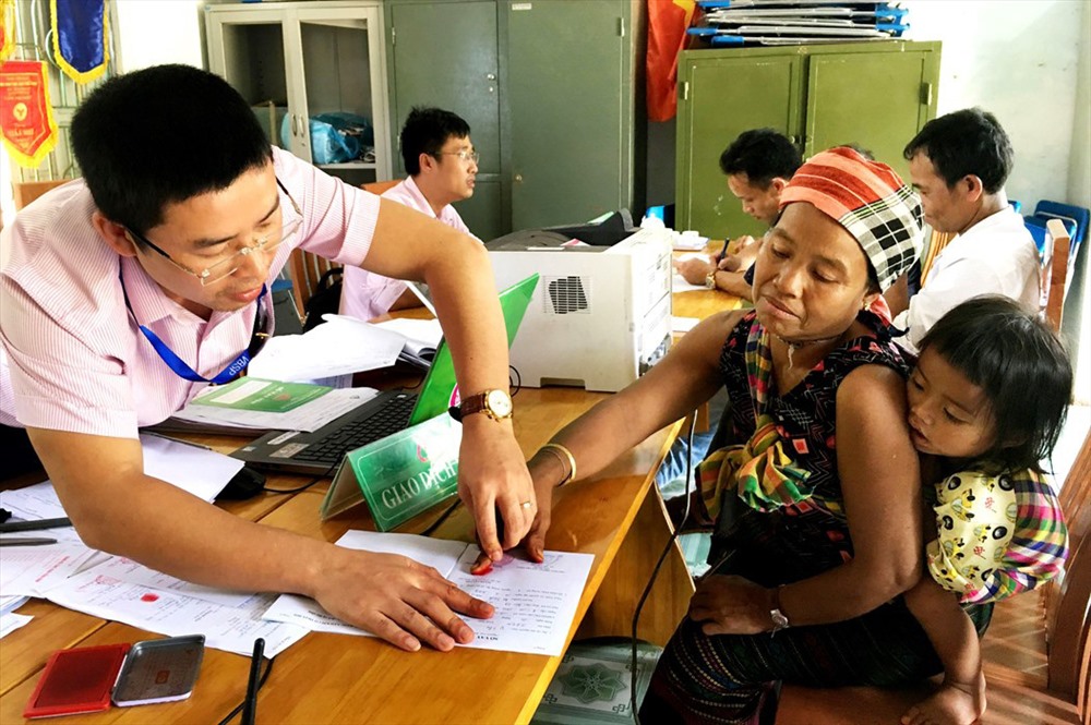 Cán bộ tín dụng đang làm thủ tục giải ngân cho đồng bào dân tộc thiểu số. Ảnh: N.H