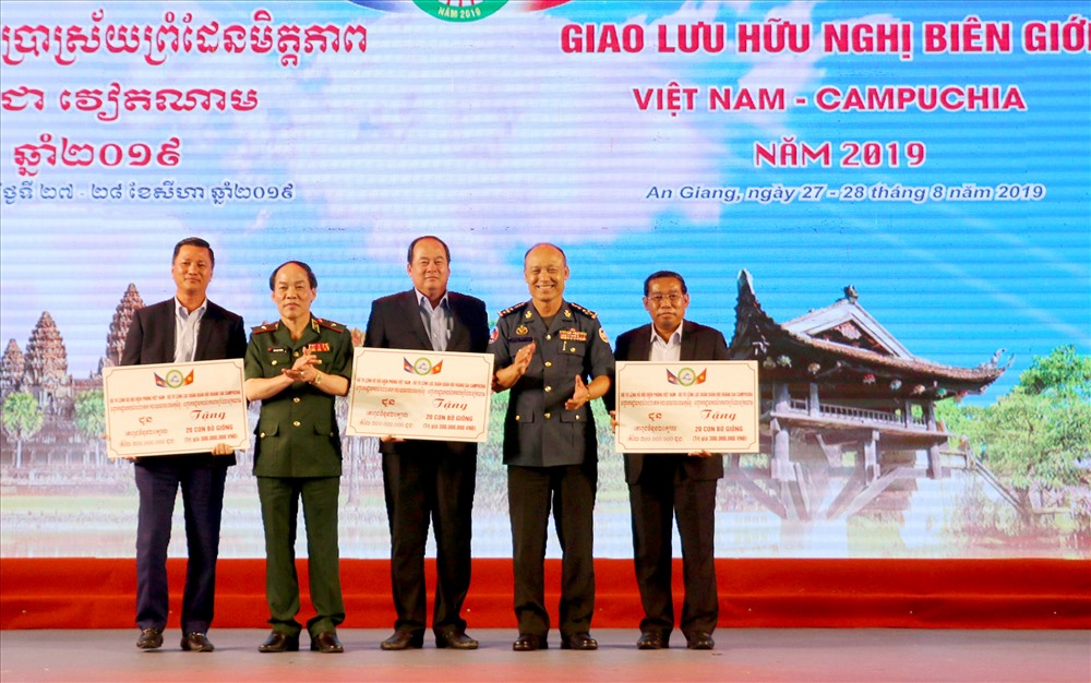 Trao biểu tượng học bổng và bò giống. Ảnh: Lục Tùng